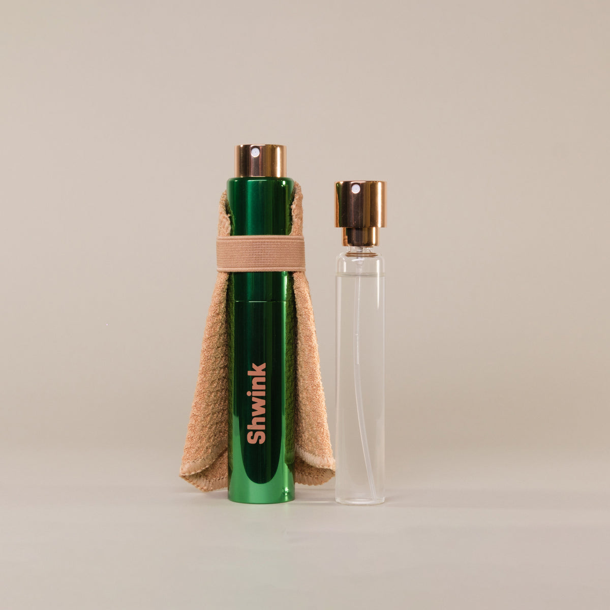 Shwink on-the-go stain spray in glossy green aluminium cylinder tube with stain lifting caramel coloured cape with refillable glass insert. 