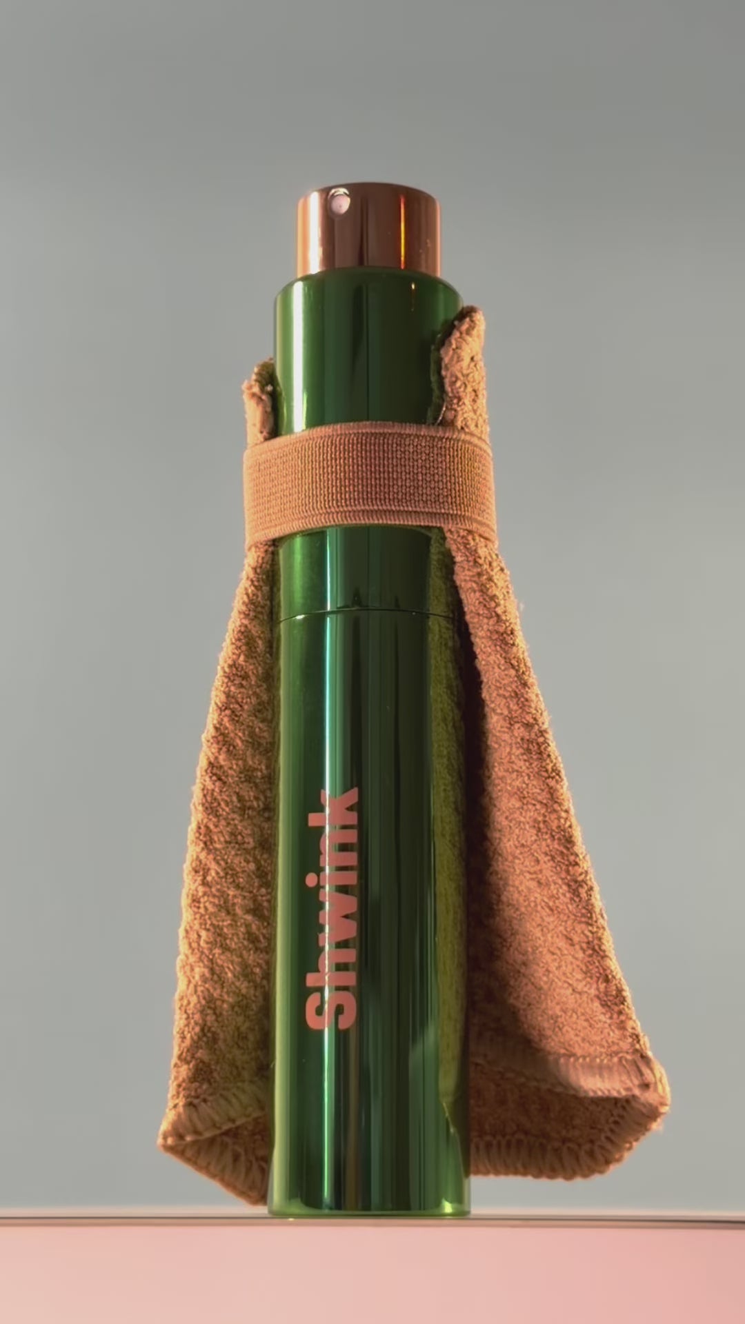 Shwink on-the-go stain spray (glossy green aluminium cylindrical tube with caramel stain lifting cape) slow motion video with lights. 